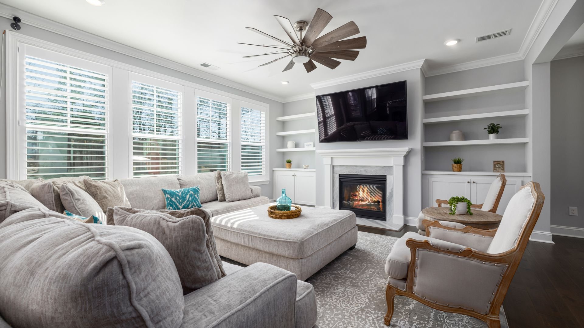 Cozy living room with fireplace, gray sectional, and large windows