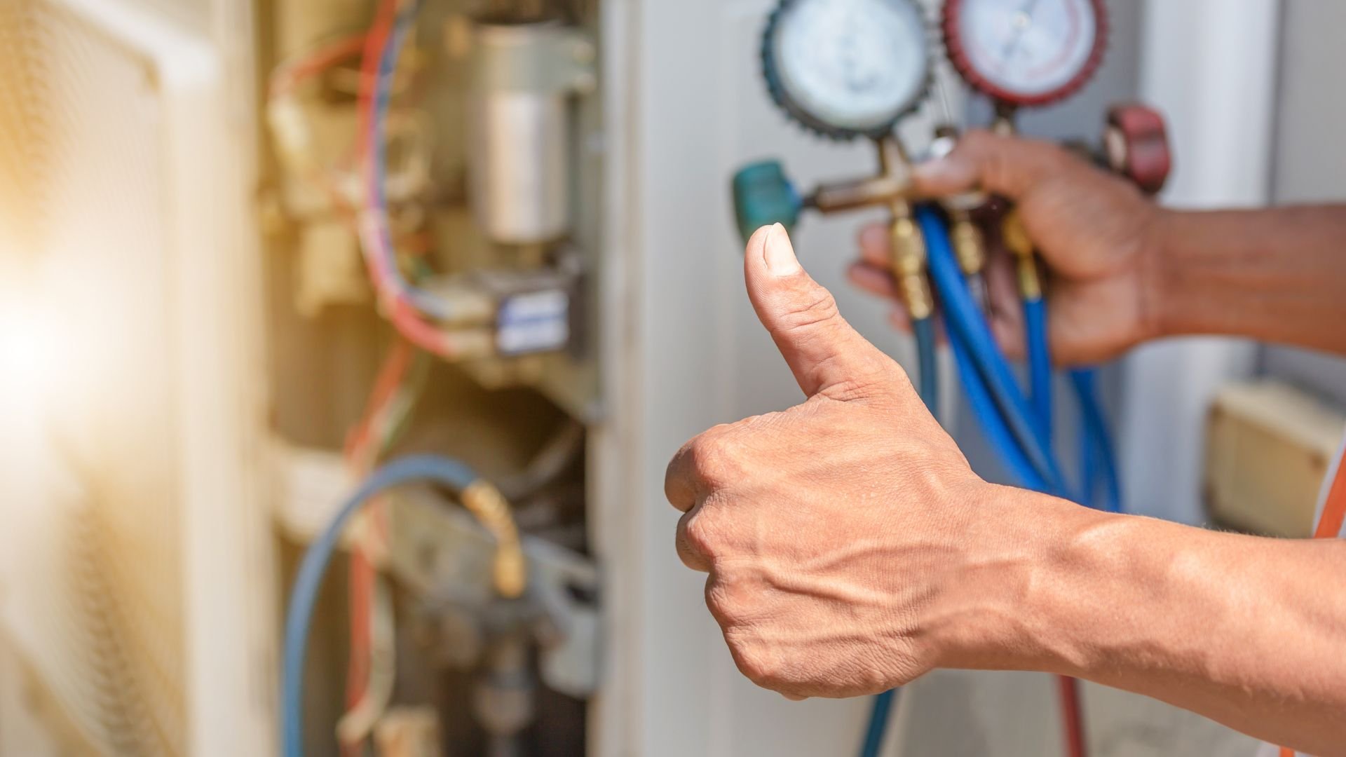 Technician giving thumbs up near pressure gauges and pipes