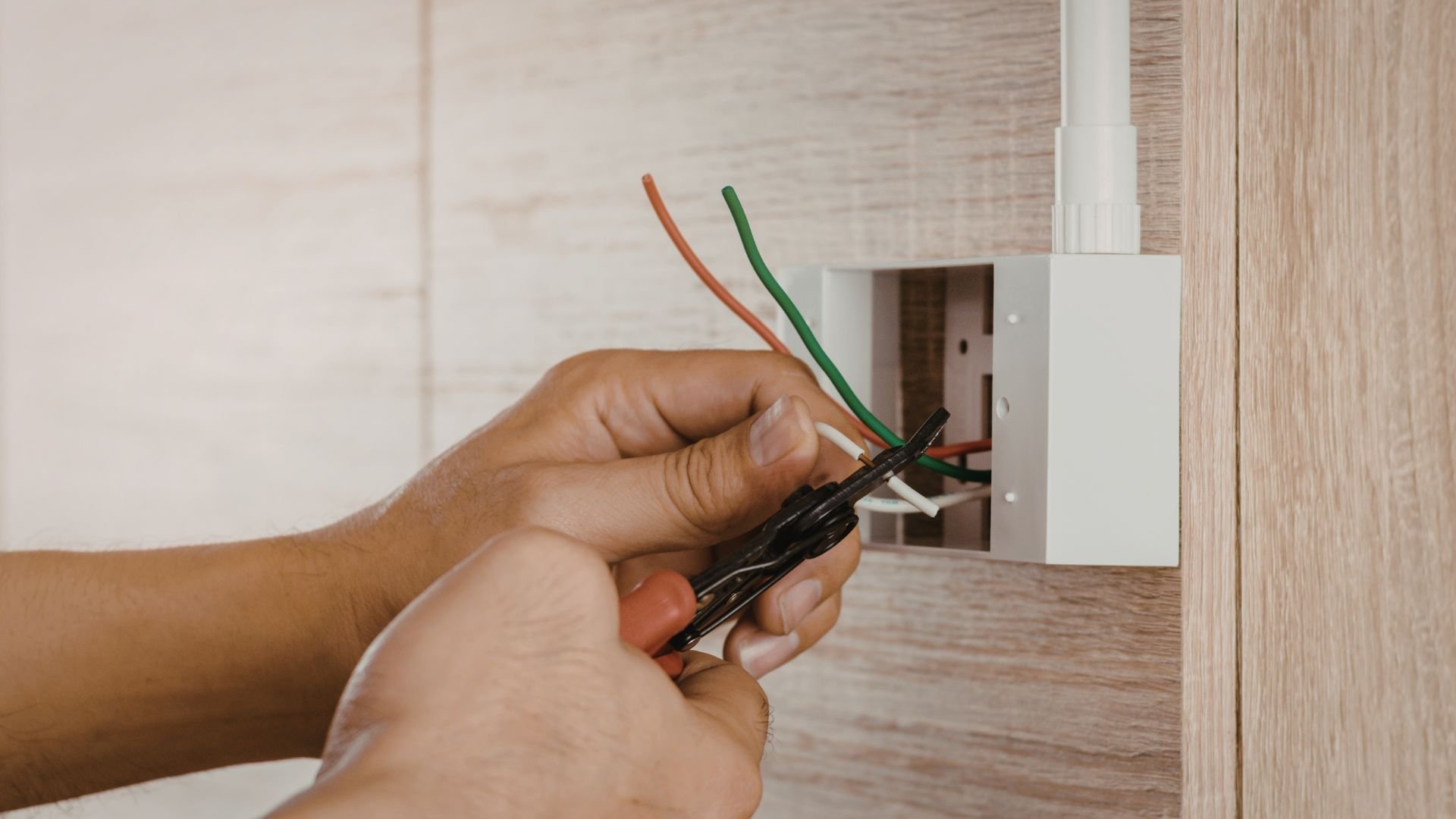 Hand stripping electrical wires for installation near wall outlet